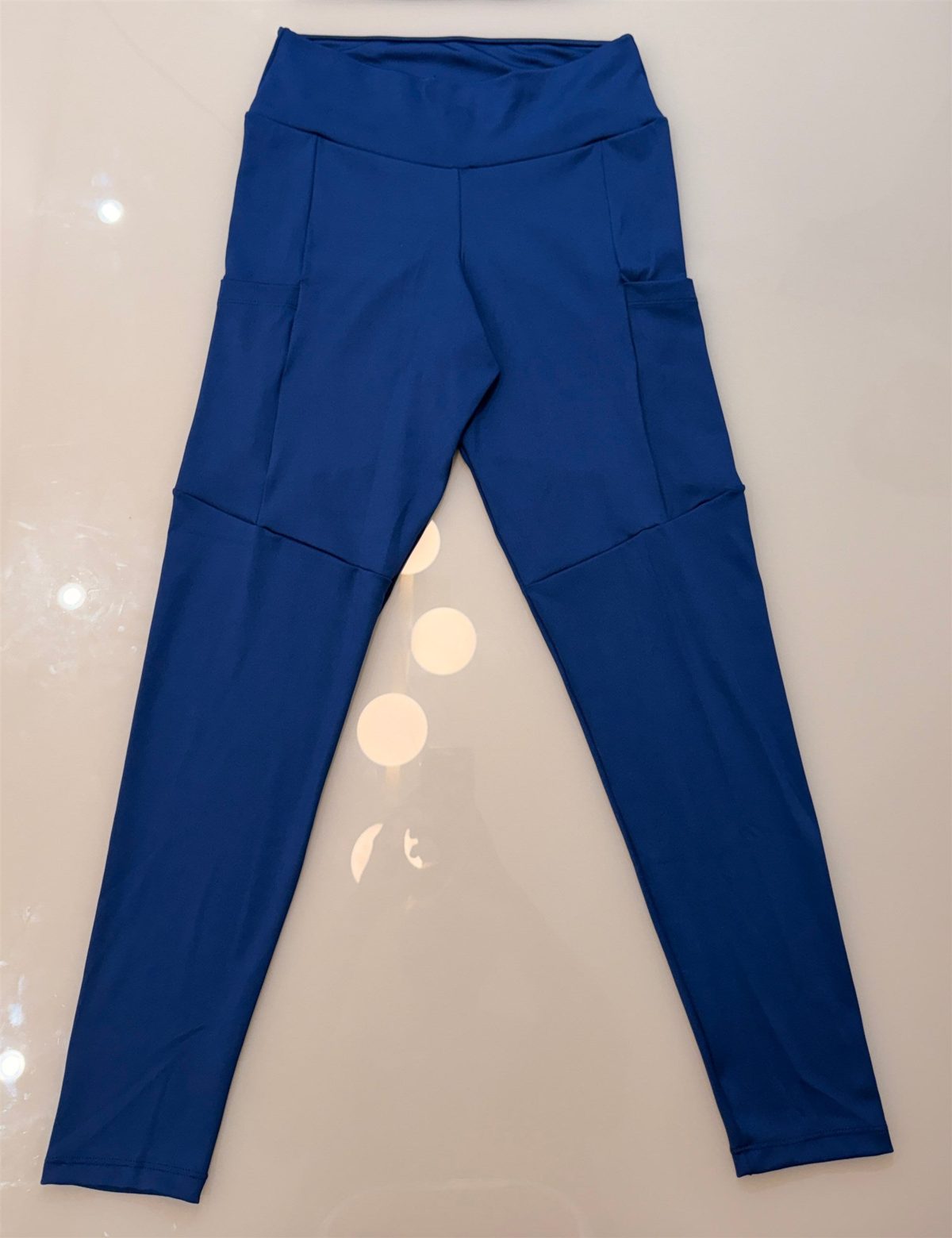 Legging Move azul esticada, mostrando os bolsos